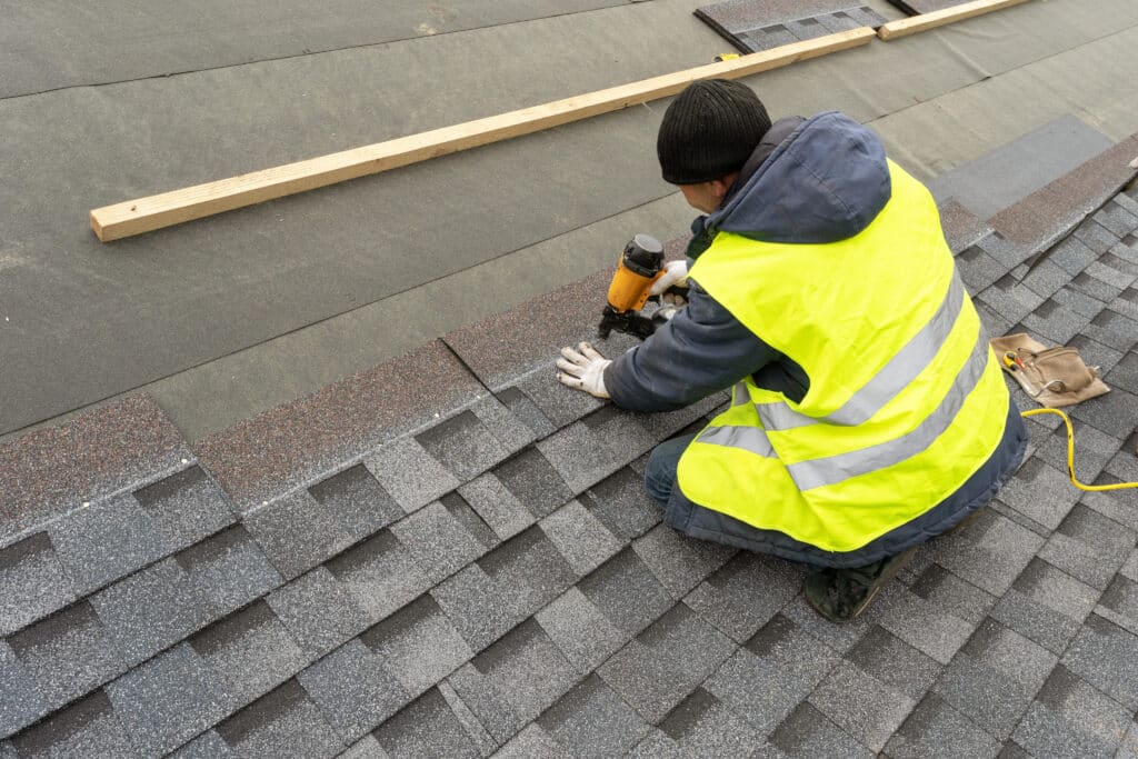 Man installing new shingles to a commercial roof