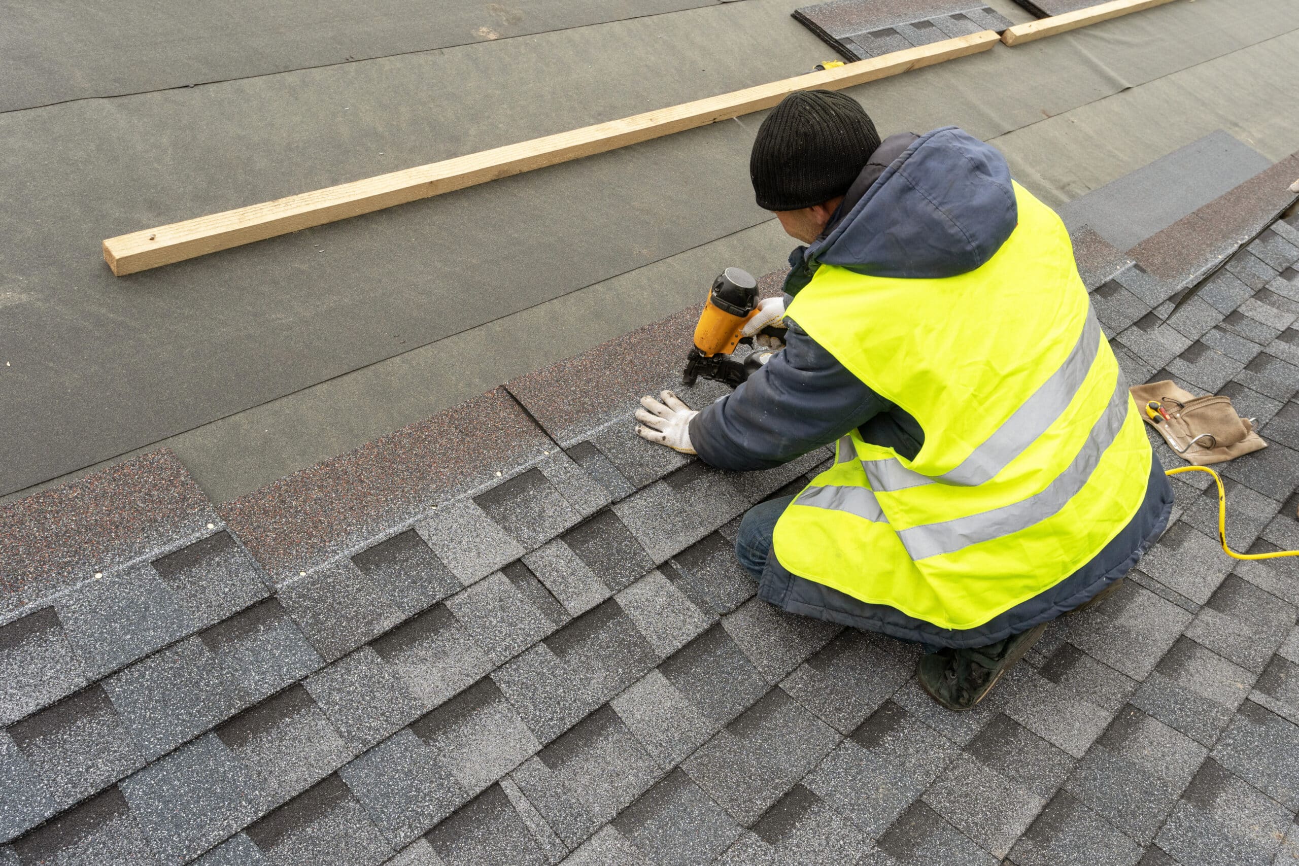 Man installing new shingles to a commercial roof